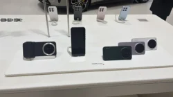 Deretan unit pajangan Xiaomi 17 Ultra di meja gerai, label bertuliskan xiaomi 17 Ultra dengan titik merah Leica, satu unit terpasang aksesori grip kamera Leica, beberapa unit Xiaomi lain digantung di penyangga pada baris belakang