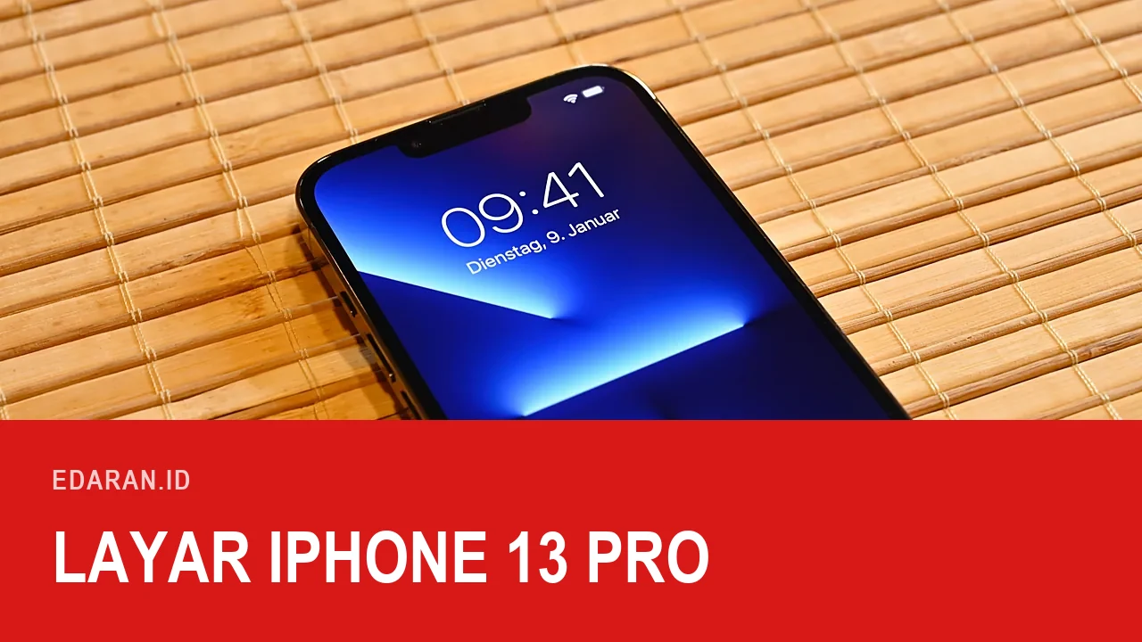 iPhone 13 Pro menyala di atas tikar bambu memperlihatkan poni dan layarnya, dengan teks judul Layar iPhone 13 Pro