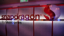 Papan bertuliskan snapdragon by Qualcomm dengan logo bulat merah di dinding sebuah acara